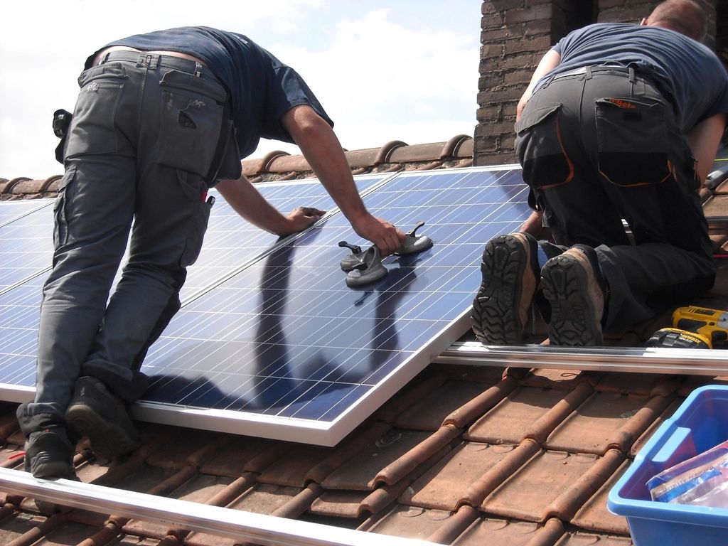 Installation team fitting solar panels on a roof